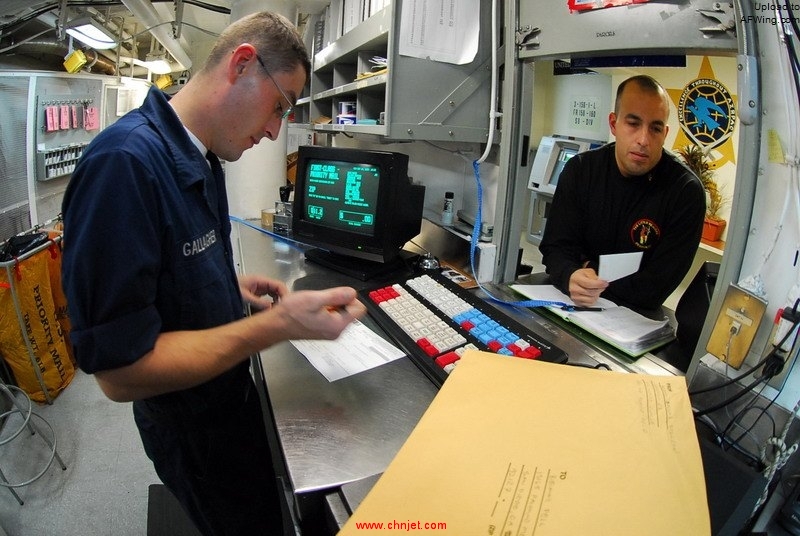 US_Navy_090928-N-2918M-103_Postal_Clerk_Seaman_Apprentice_Noel_Gallagher_assists_Chief_Sonar_Technician_Armando_Berajas_with_mail_in_the_post_office_aboard_the_aircraft_carrier_USS_Nimitz_%28CVN_68%29.jpg